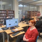 Kobieta siedzi przy biurku i pracuje na komputerze podczas warsztatów z zakresu tworzenia CV.