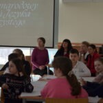 Uczniowie siedzą przy stolikach w sali lekcyjnej podczas zajęć z okazji Dnia Języka Ojczystego.