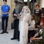 Uczestnicy konwentu przebrani za postacie ze Śródziemia występują publicznie z mikrofonami.