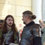 Dwóch mężczyzn przebranych za rycerzy rozmawia podczas konwentu inspirowanego twórczością J.R.R. Tolkiena.